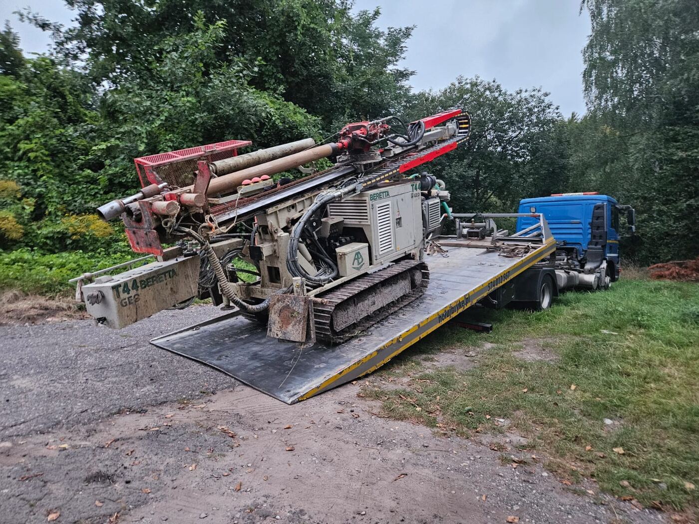 MAN TGL 12.250 z płytą hydrauliczną przy załadunku maszyny